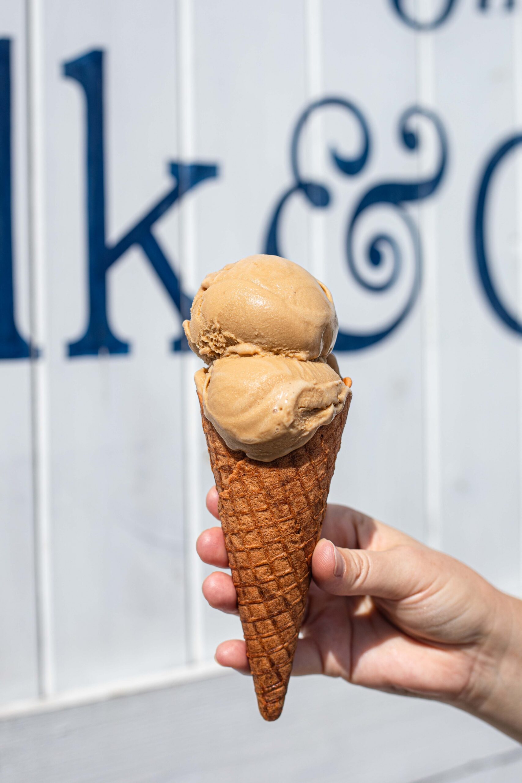 Someone holding ice cream in front of barn door mural